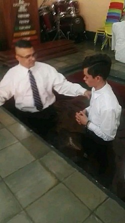 Pastor Óscar A. Cubillo bautizando al joven Abraham canales